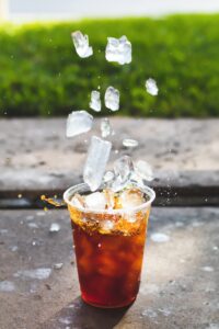Dropping ice cubes into a cup of iced tea